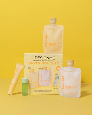 A collection of hair care products including a BOUNCE.ME Curl shampoo, conditioner, curl balm, and hair oil from the DESIGNME Curl Discovery Kit presented on a yellow background.