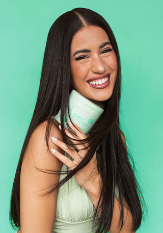 Model holding GLOSS.ME Hydrating Treatment Mask, a deeply moisturizing mask for smoother, shinier hair.