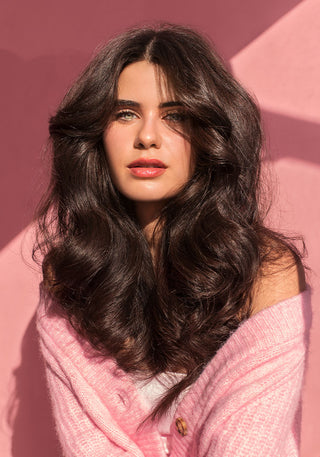 Model with long, healthy, shiny, and voluminous hair after using the DESIGNME Volume Styling Bundle.