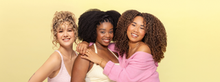 Three models with 2C, 4B, and 4C curly hair textures posing together.